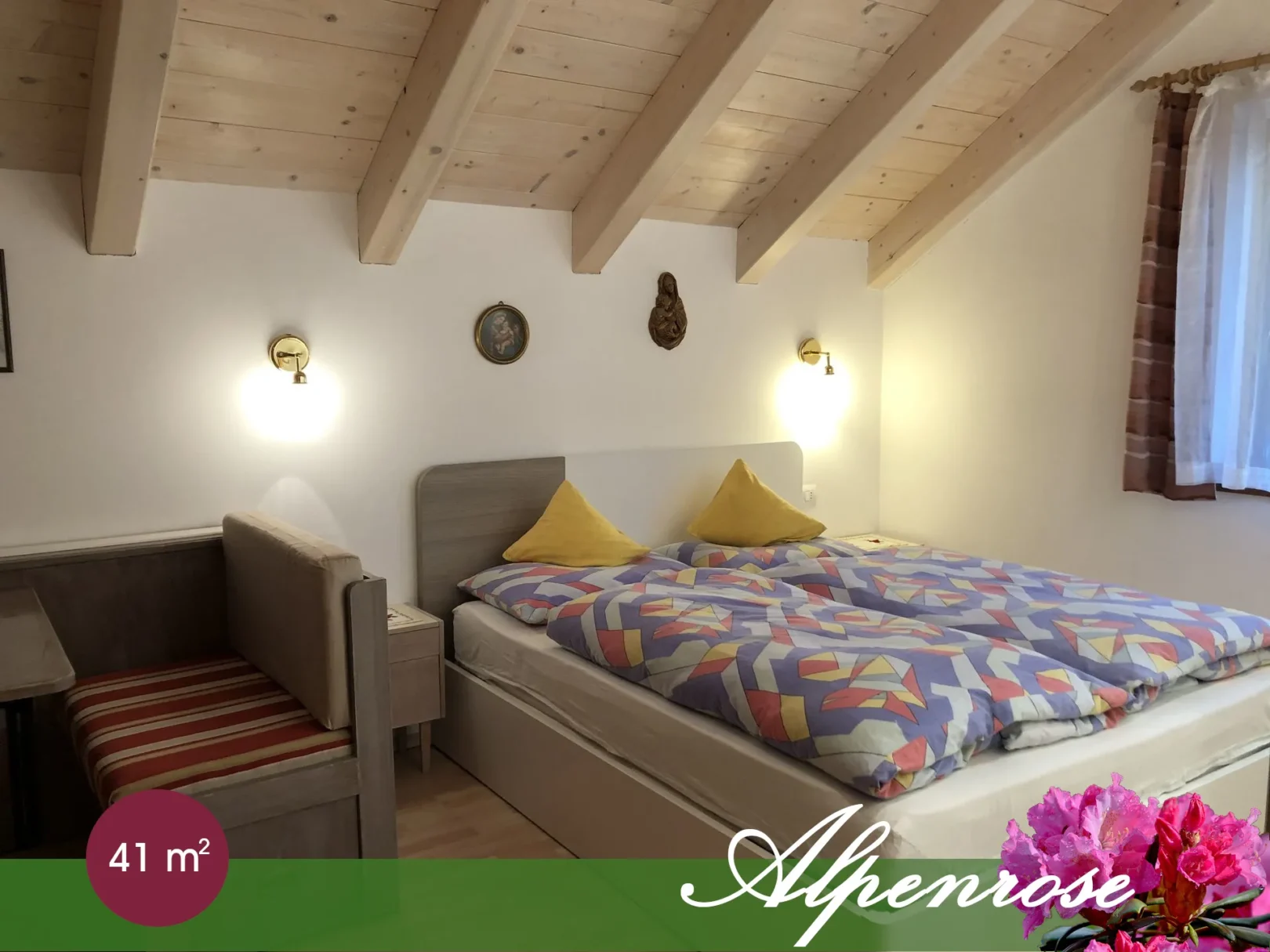 Camera matrimoniale dell’appartamento Alpenrose con soffitto a travi in legno