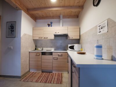 Cucina dell’appartamento Edelweiss con mobili chiari e forno a microonde