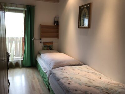 Cameretta dell’appartamento Geranie con letto singolo e porta sul balcone