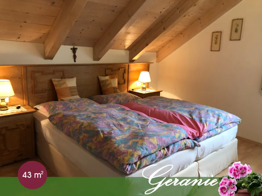 Camera matrimoniale dell’appartamento Geranie sotto il soffitto in legno