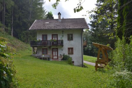 Dependance del maso Hofer Hof con balcone in legno e prato davanti alla casa
