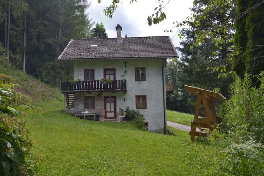 Dependance del maso Hofer Hof con balcone in legno e prato davanti alla casa