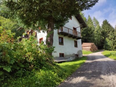 Dependance del maso Hofer Hof con balcone in legno accanto alla stradina