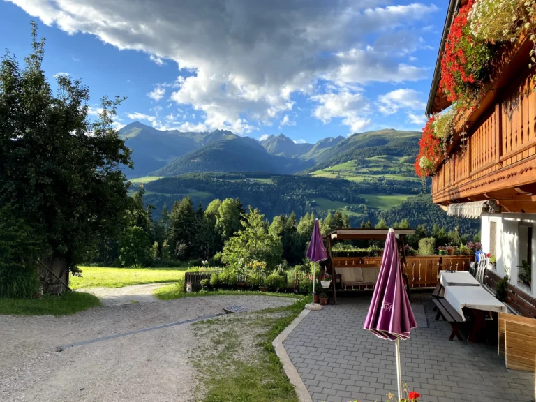 Terrazza del maso Hofer Hof con ombrelloni e vista sulla valle