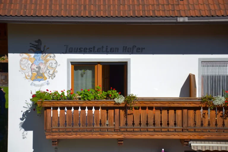 Insegna della Jausenstation Hofer sopra un balcone fiorito