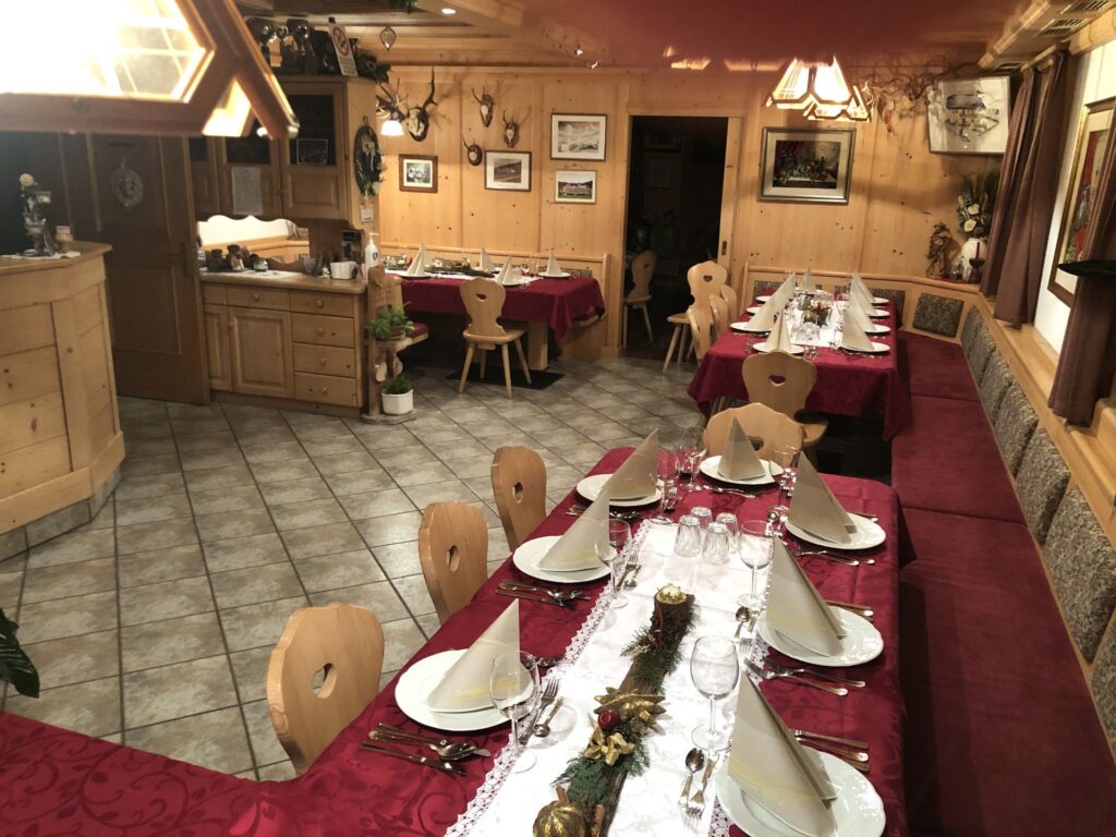 Sala della Jausestation Hofer Hof con arredi in legno e tavoli apparecchiati
