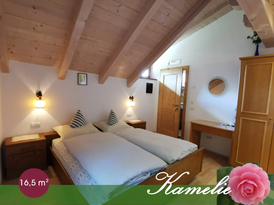 Camera Kamelie con letto matrimoniale e soffitto a travi in legno
