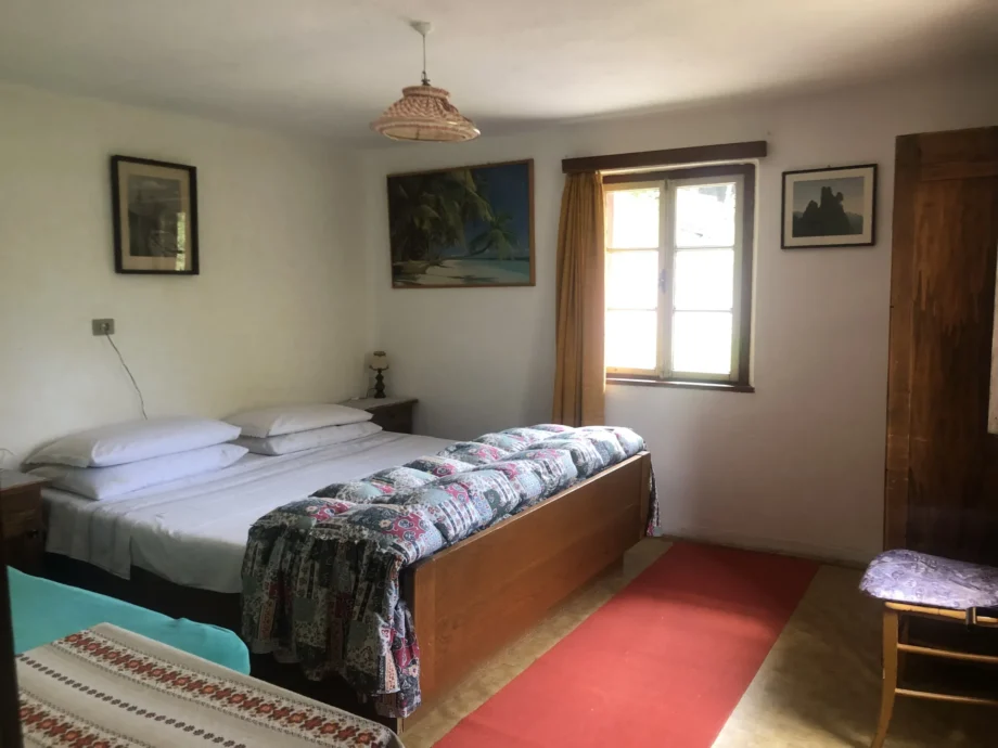 Letto matrimoniale e arredi in legno nella camera al primo piano della dependance