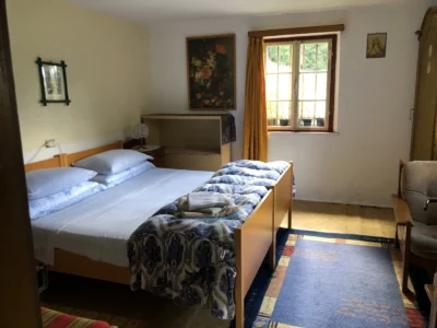 Letto matrimoniale e finestra nella camera al piano terra della dependance