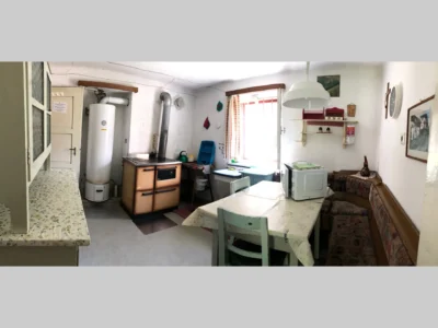 Cucina della dependance al piano terra con tavolo e panca in legno