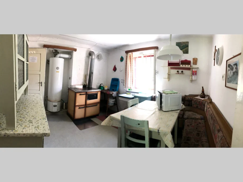 Cucina della dependance al piano terra con tavolo e panca in legno