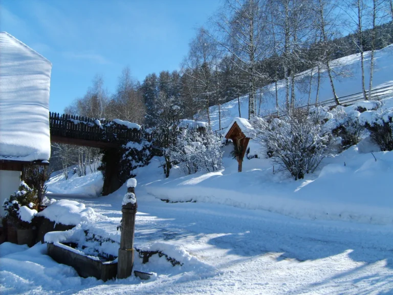 Fontana e giardino del maso Hofer Hof coperti di neve