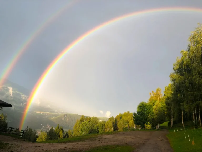 Doppio arcobaleno sopra la valle e i prati vicino al maso Hofer Hof