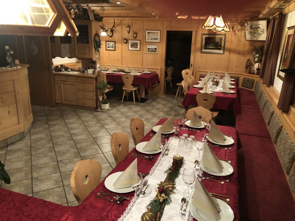Interno della Jausestation Hofer Hof con tavoli apparecchiati e arredi in legno